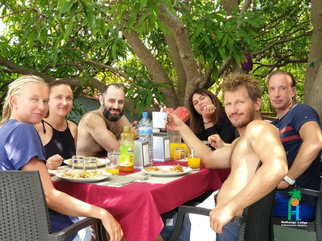 Guests eating breakfast under a mango tree