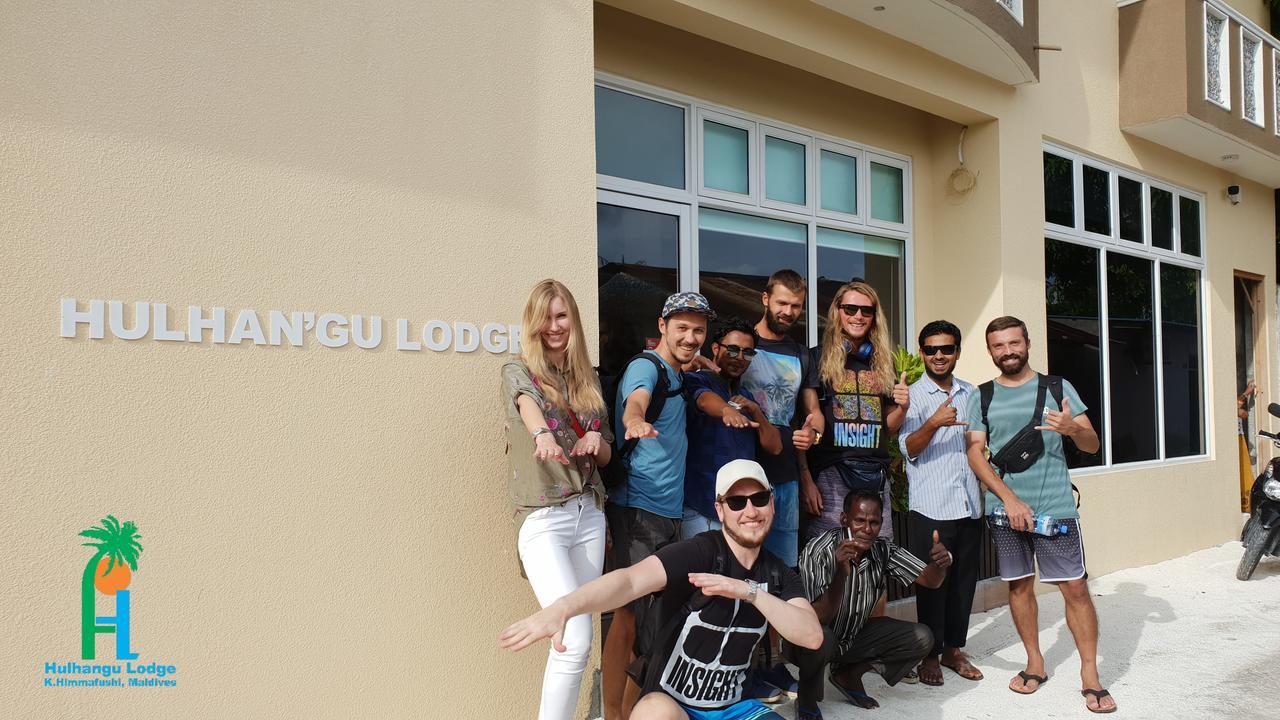 Guests and staff posing together outside the Hulhan'gu Lodge entrance
