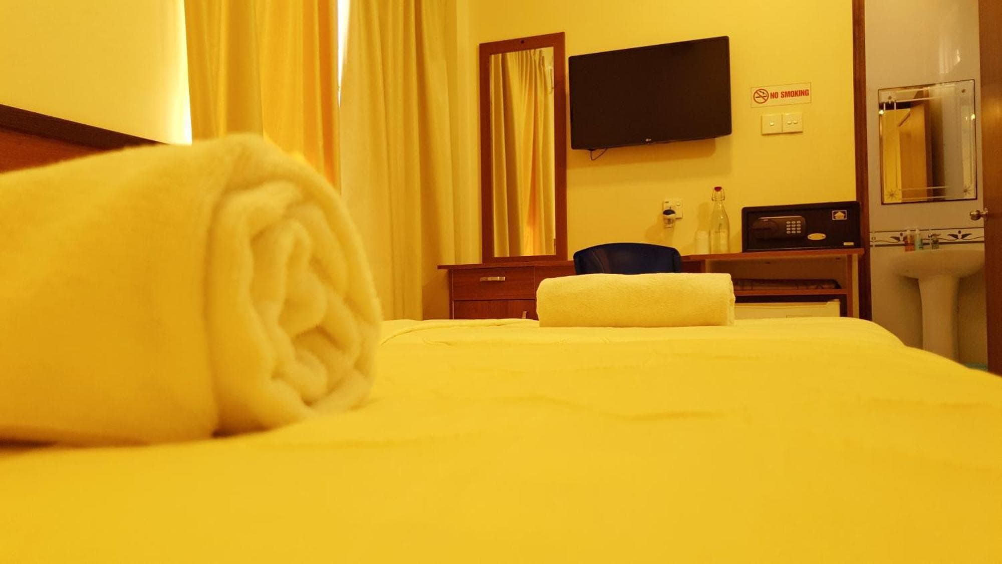 Rolled towels set out on a made bed