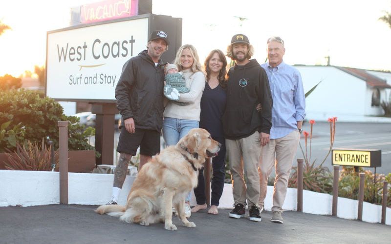 Dave and AnnMarie Cinquini and family at sunset under the West Coast Surf and Stay sign