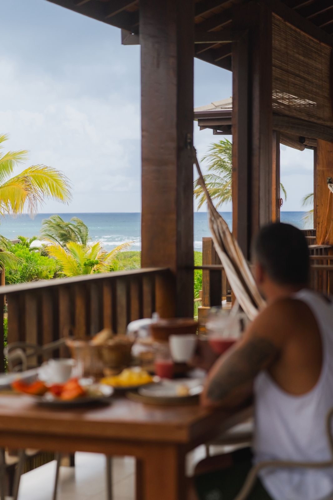 Breakfast on the veranda with fruit and coffee, a hammock, and the ocean beyond
