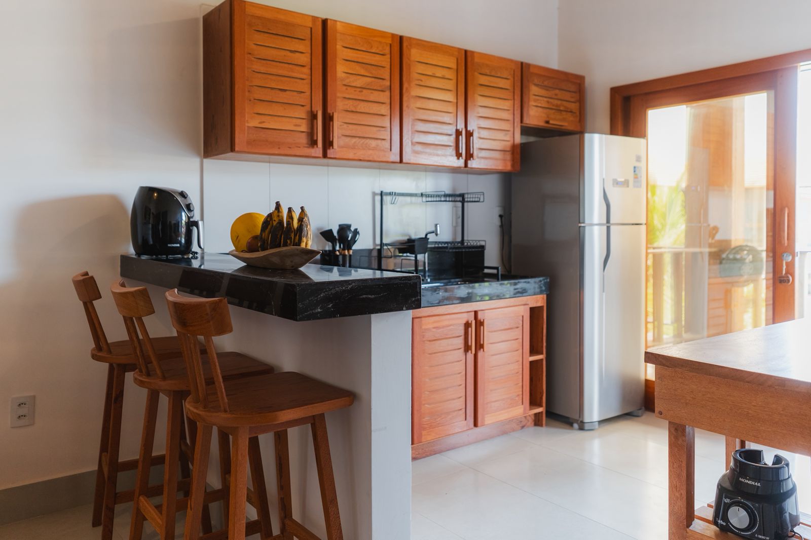 Kitchen with hardwood cabinets, stone counter and bar stools