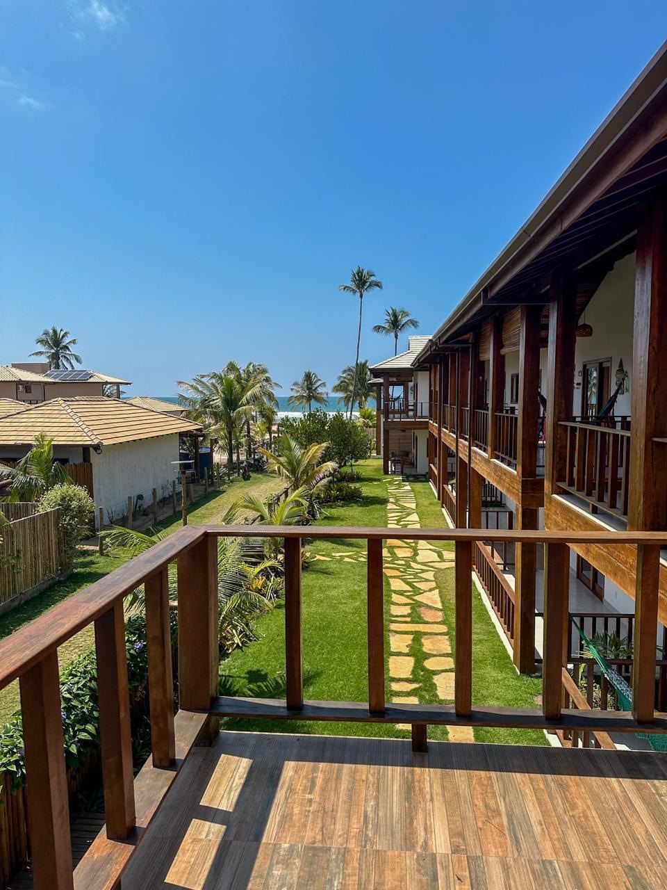 Stone path running through the lawn toward the ocean, with a hammock strung on the walkway