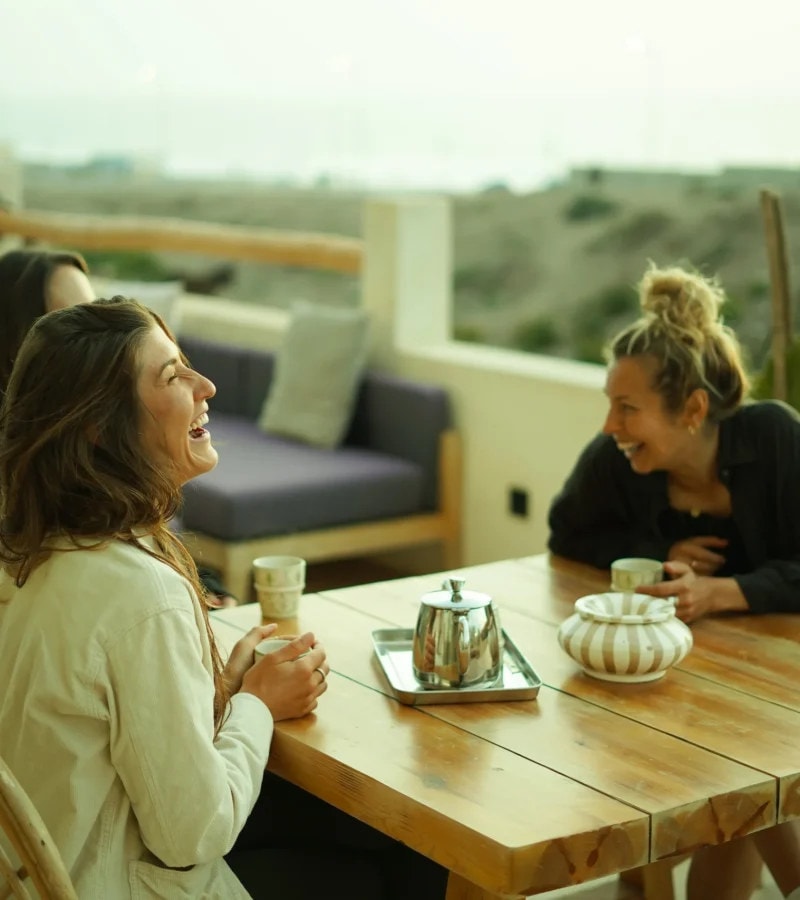 Two guests with tea at a table on the lodge terrace